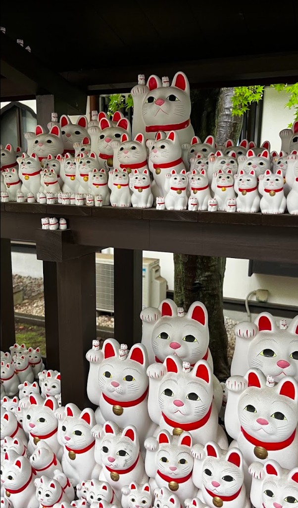 rows of maneki-neko lucky cats at gotokuji