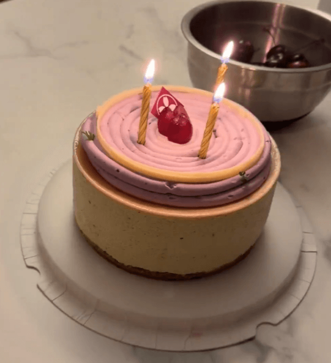 Grape oolong cake from Bloom Cafe with purple and cream frosting and a cherry on top, with birthday candles