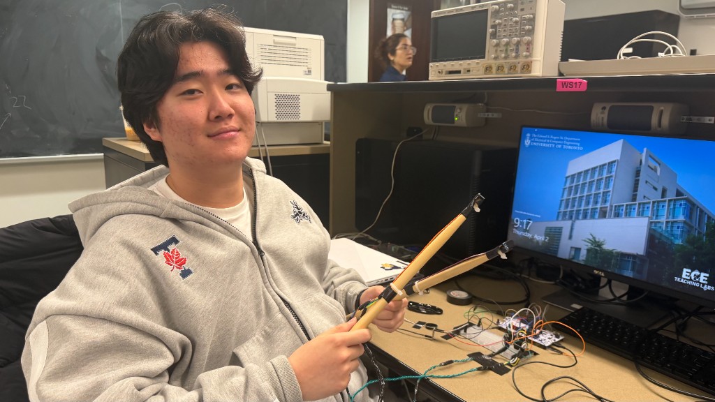Holding two drumsticks with BNO055 IMUs mounted on them, wired back to an STM32 on a breadboard in the lab