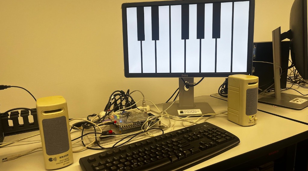 The physical setup: DE1-SoC board, PS/2 keyboard, and stereo speakers on a desk