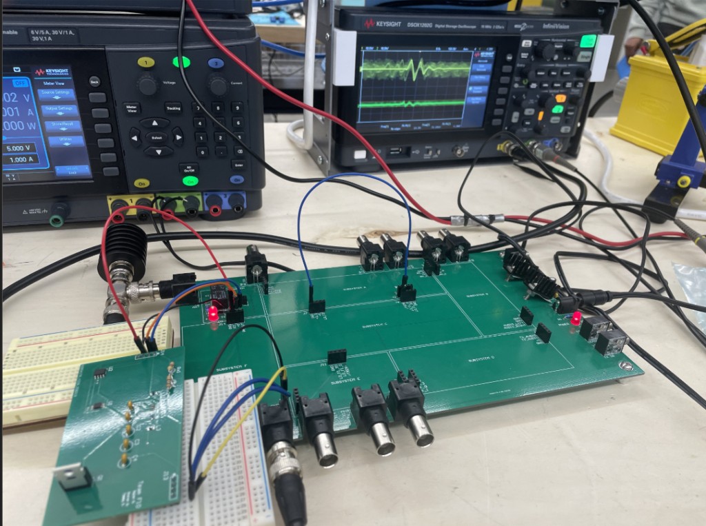 Bench test setup: the board wired in through breadboards and jumpers, probed on a Keysight oscilloscope